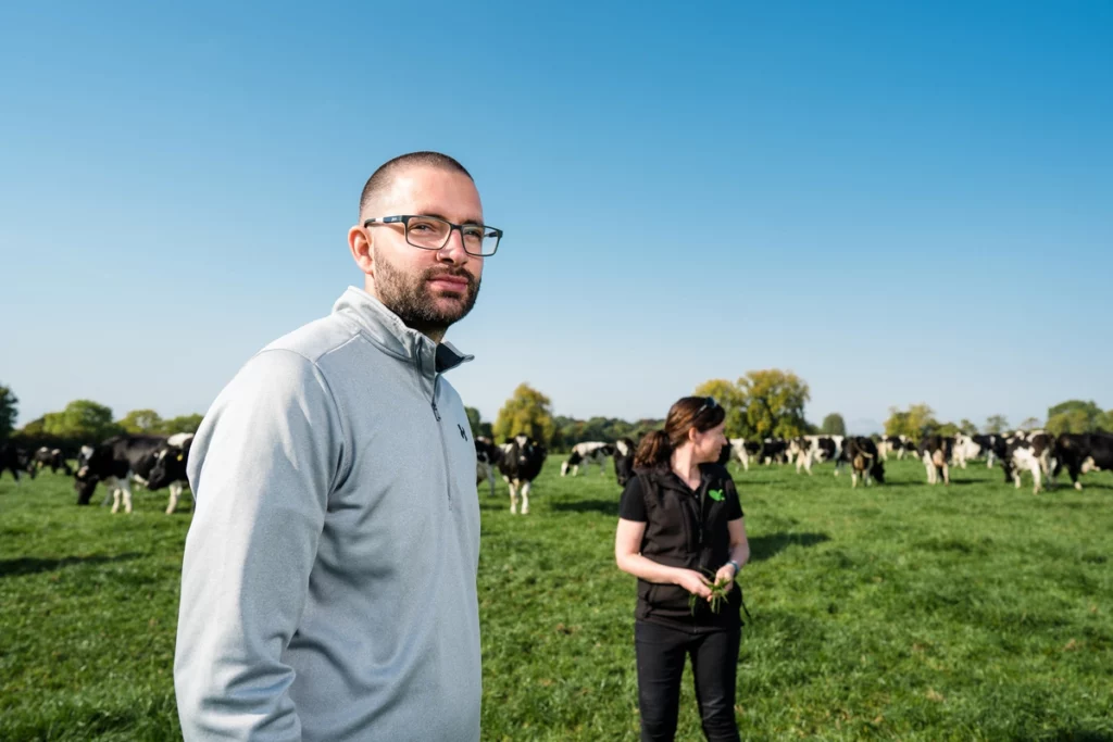 Farmer Niall Moloney in field with dairy cattle in background